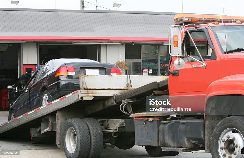 Tow truck bringing a car at the car repair shop.
